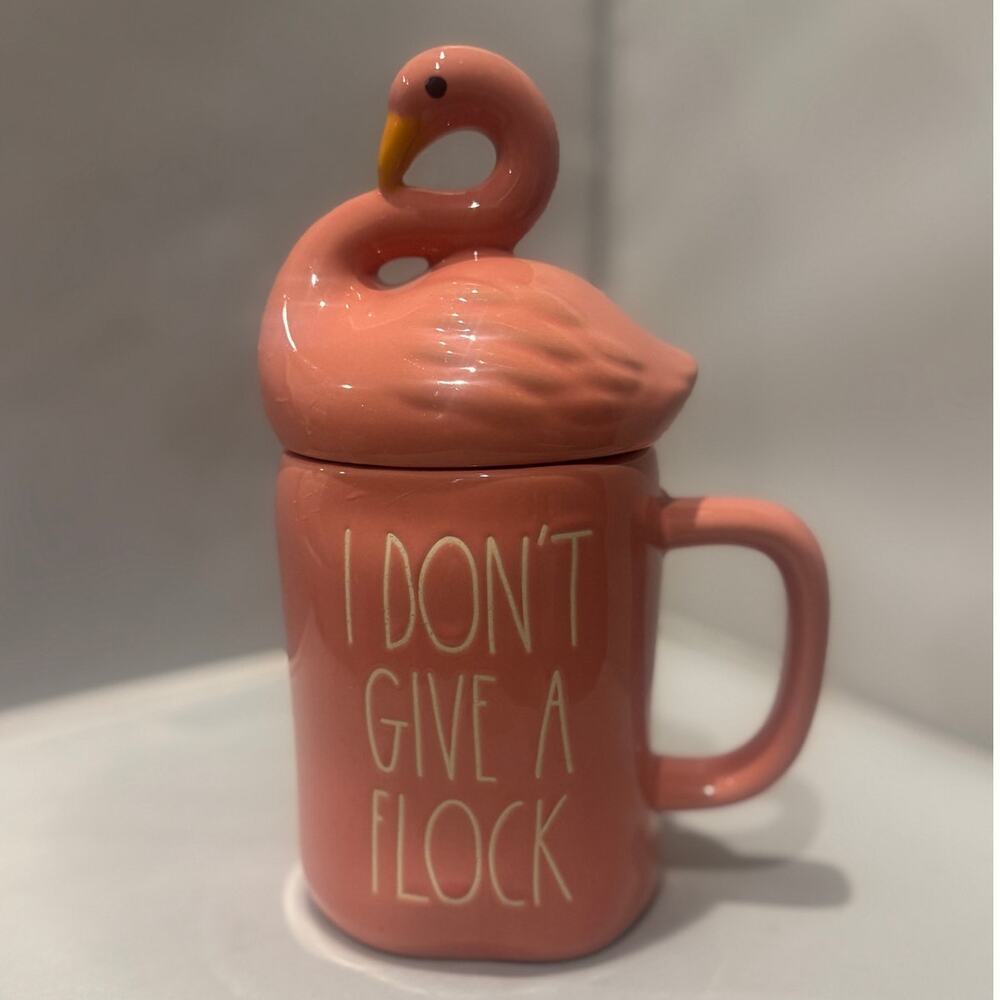 Rae Dunn "I Don't Give A Flock" mug with a ceramic flamingo lid.